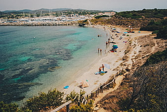 Aerial View of Turquoise Beach with Harbor and Sailboats
