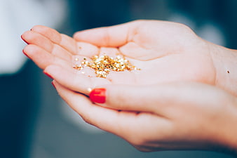 Close-up of female hands holding gold glitter