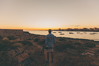 Photographer with Camera Looking at Coastal Sunset