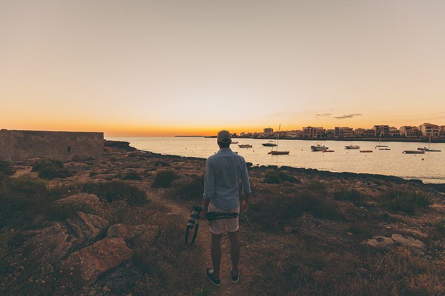 Photographer with Camera Looking at Coastal Sunset