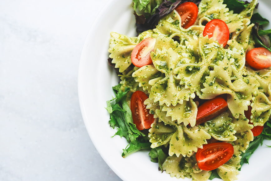 Farfalle Pesto Pasta with Cherry Tomatoes on White Plate