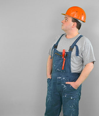 Construction Worker in Overalls Looking Up with Hard Hat