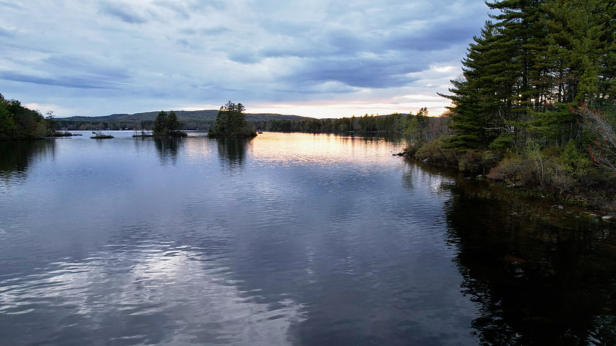 Serene Lake Landscape at Dusk with Forest and Cloudy Sky