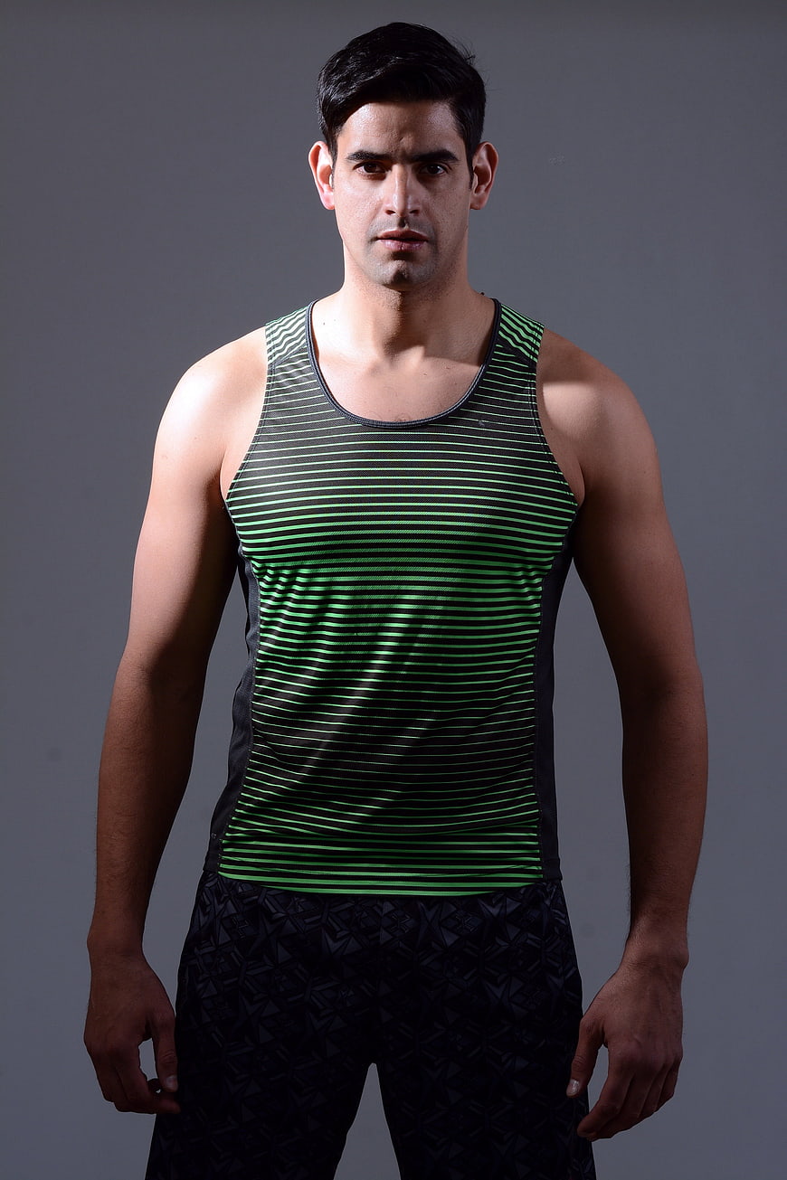 Portrait of a male fitness coach in a green striped tank top