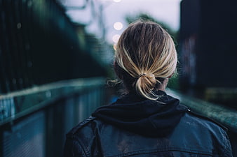 Back view of woman with blonde bun in leather jacket