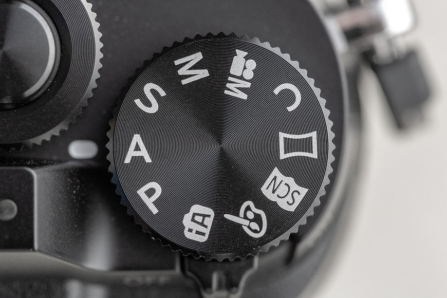 Close-up of camera mode dial with photography settings