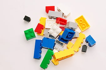 Colorful plastic building blocks scattered on white background