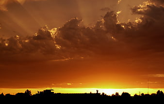 Dramatic orange sunset sky with clouds and silhouette