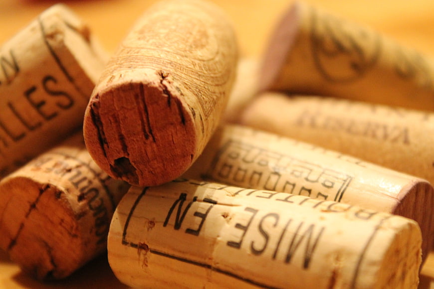 Close-up of wine corks with text on wooden background