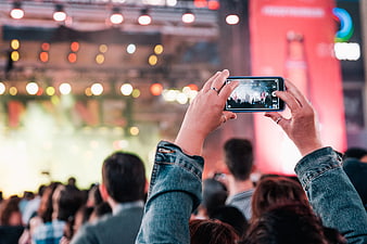 Hands Holding Smartphone Recording Live Concert Performance