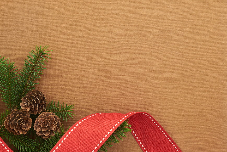 Christmas Pine Branches and Red Ribbon on Kraft Paper Background
