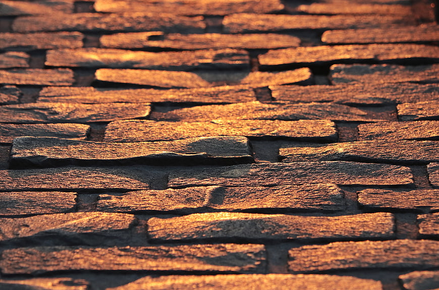 Warm Golden Light On Textured Cobblestone Pavement Surface