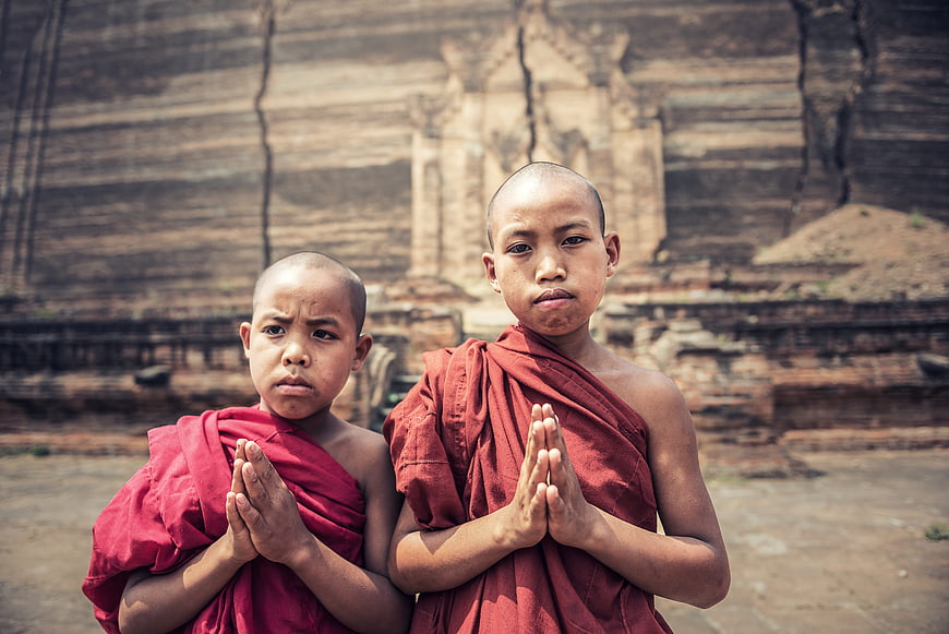 Two young Buddhist novice monks praying in Myanmar