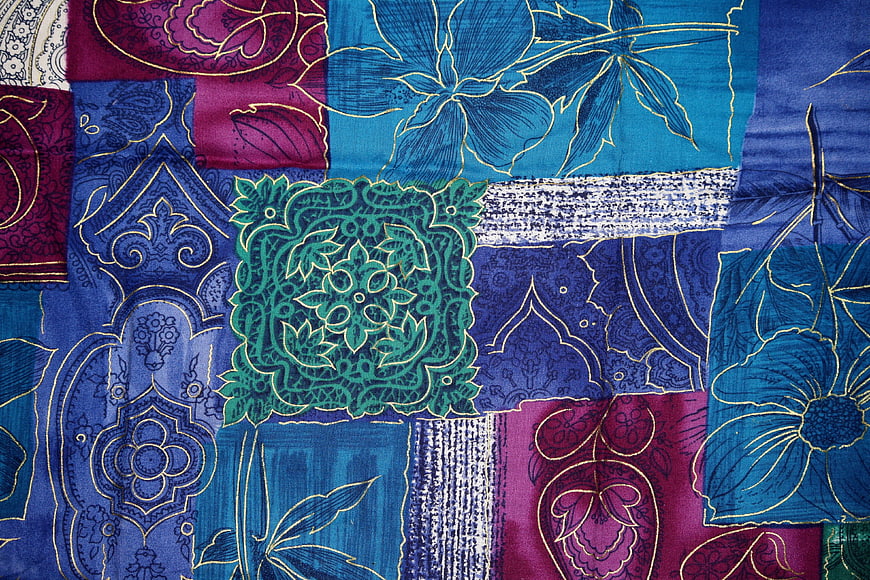 Colorful patchwork textile pattern with floral and paisley designs