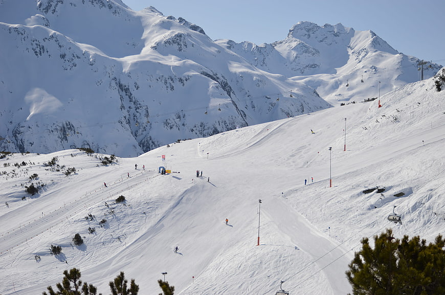 Wide View of Snowy Alpine Ski Slope with Mountains
