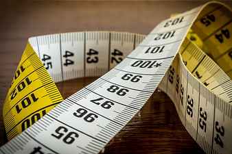 Close-up of yellow and white tailor measuring tape on wood