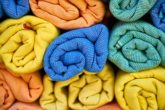 Colorful rolled towels in vibrant yellow, blue, and orange