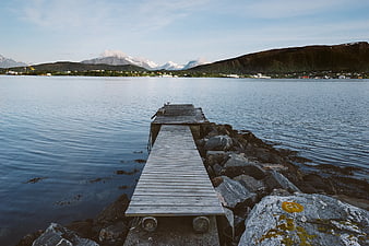 Wooden Dock Leading to Calm Water with Mountains