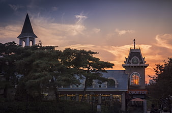 European-style architecture with clock tower and steeple at sunset