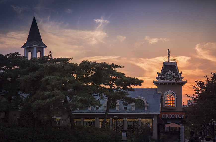European-style architecture with clock tower and steeple at sunset