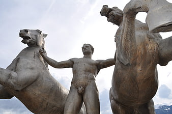 Low angle view of bronze statue with man and horses