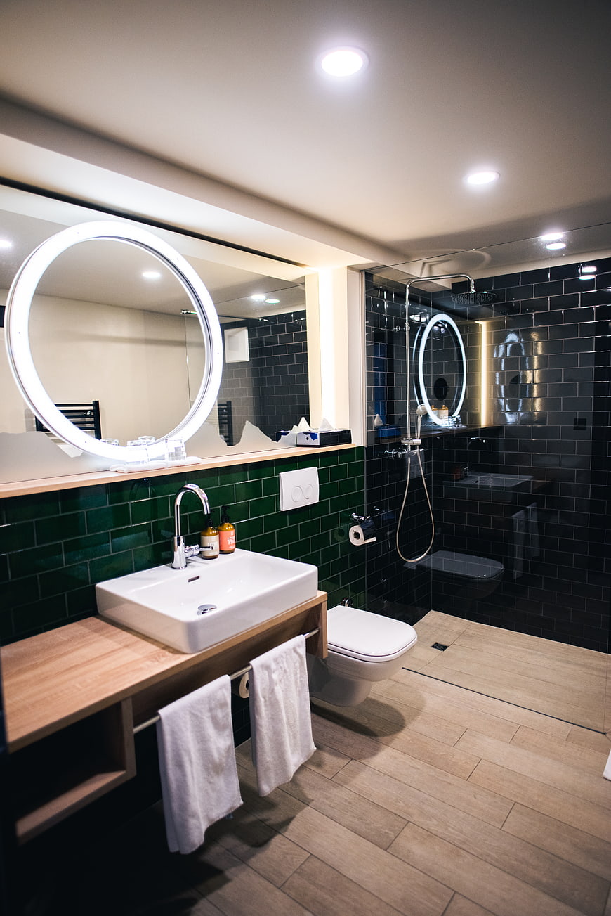 Modern Bathroom Interior with Green Tiles and Wooden Vanity