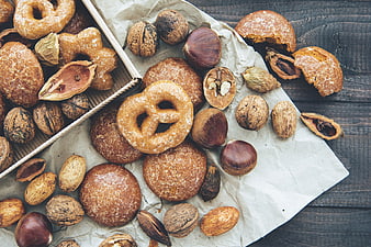 Top view of assorted nuts and sweet pastries on rustic wood