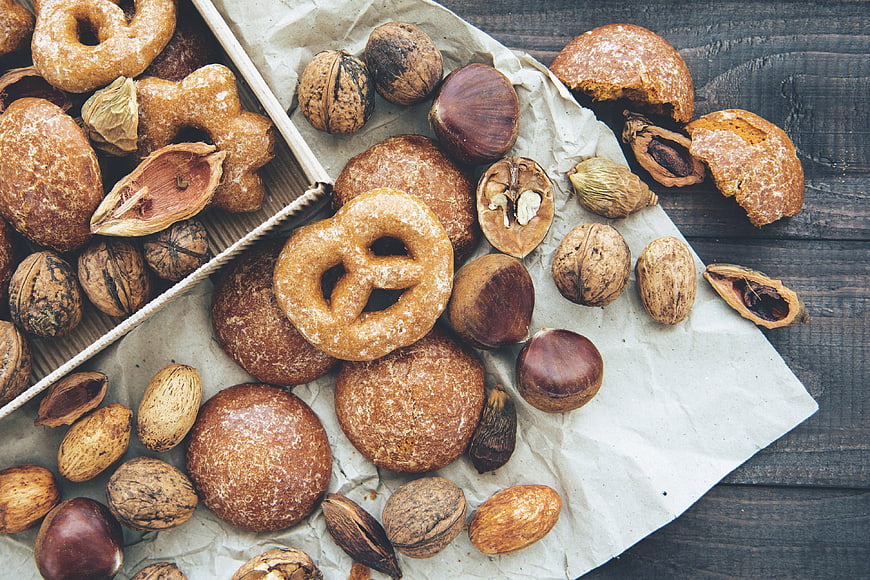 Top view of assorted nuts and sweet pastries on rustic wood