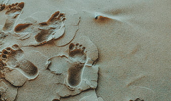 Barefoot footprints in dry cracked sand texture