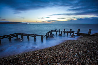 Long Exposure Wooden Groynes on Pebble Beach at Dusk
