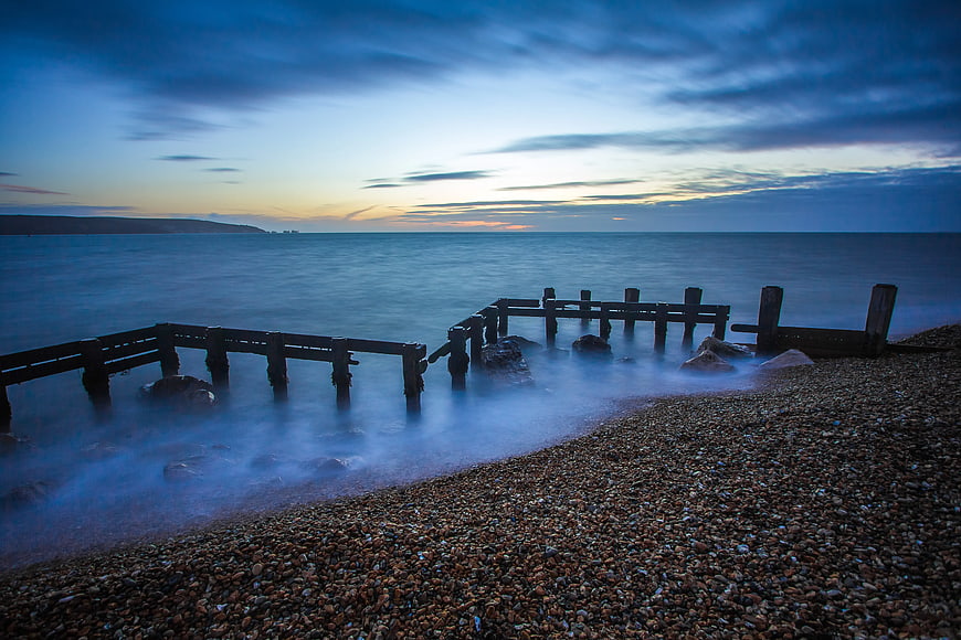 Long Exposure Wooden Groynes on Pebble Beach at Dusk