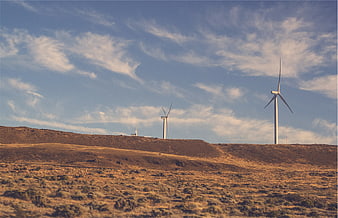 Wind turbines on arid hills under blue sky