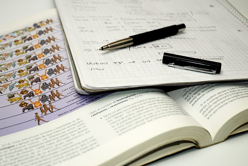 Biology textbook and handwritten notes on evolution