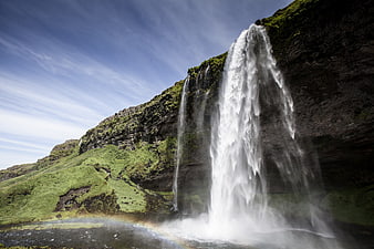 Seljalandsfoss Waterfall in Iceland with Rainbow and Green Cliffs
