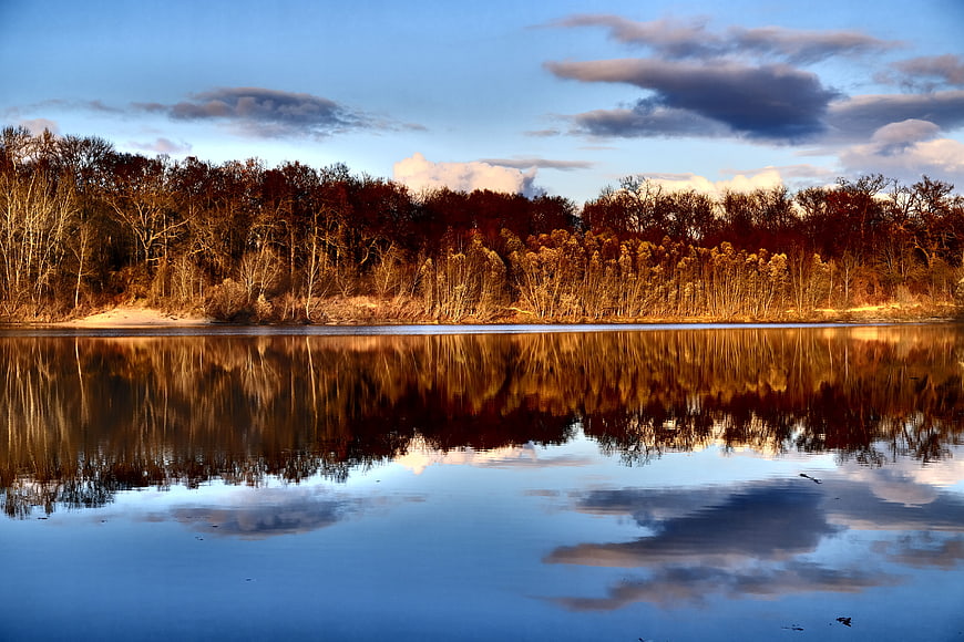 Serene Lake Reflection with Golden Forest and Blue Sky