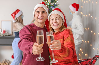 Happy couple toasting with champagne at Christmas party