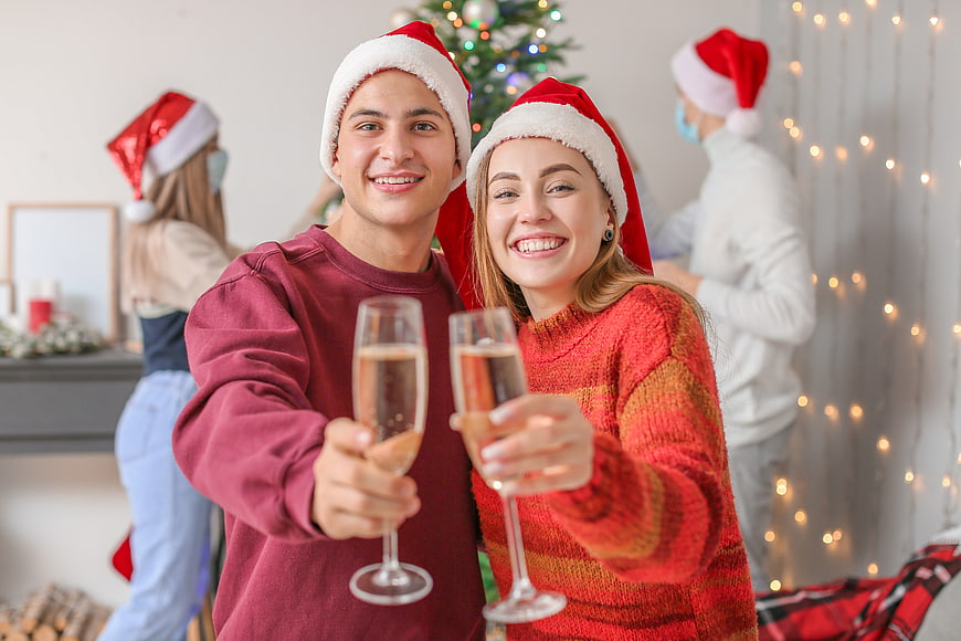 Happy couple toasting with champagne at Christmas party