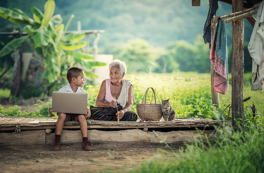 Grandmother and Boy with Laptop in Rural Village