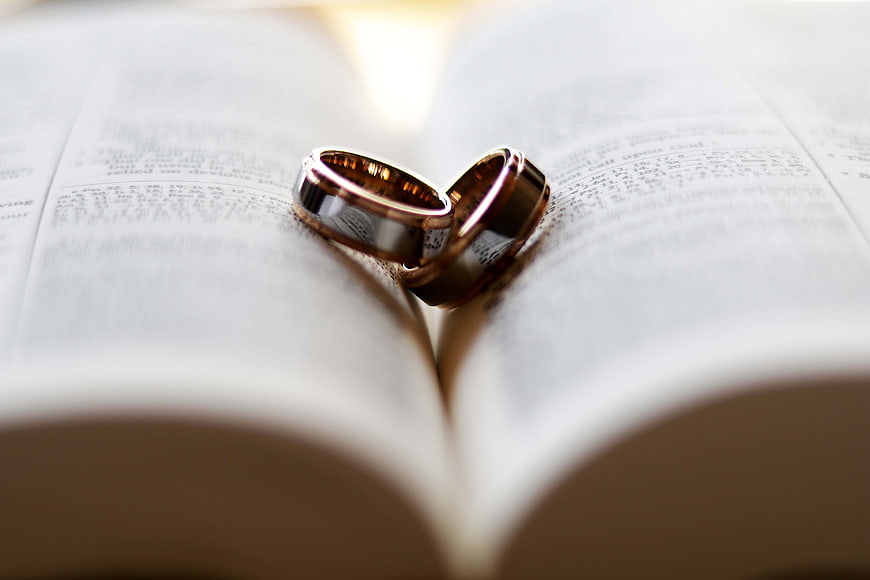Gold Wedding Rings on Open Bible Pages