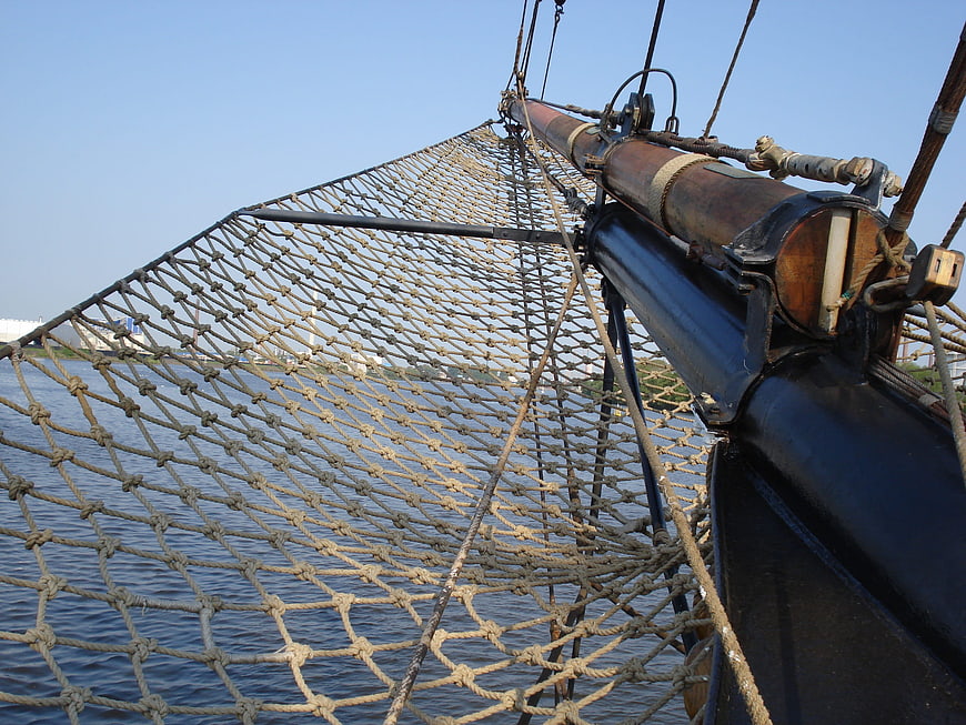 Close-up of ship rigging and safety net over water