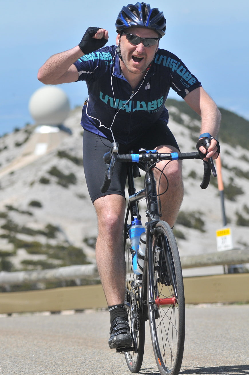 Male Cyclist Celebrating Victory On Mountain Road