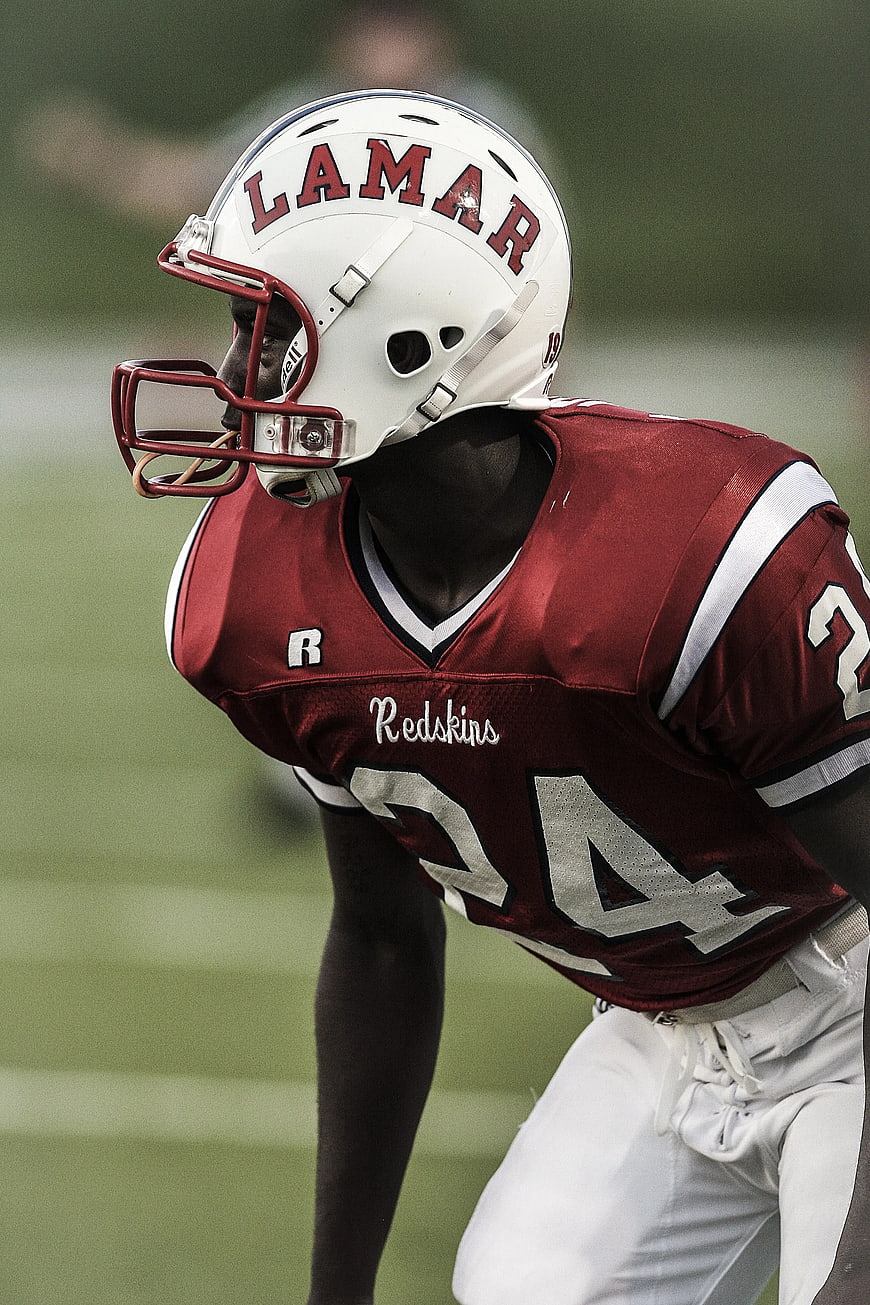 American Football Player in Maroon Uniform on Field