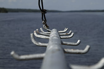 Close-up of metal boat oarlock against blurred lake background