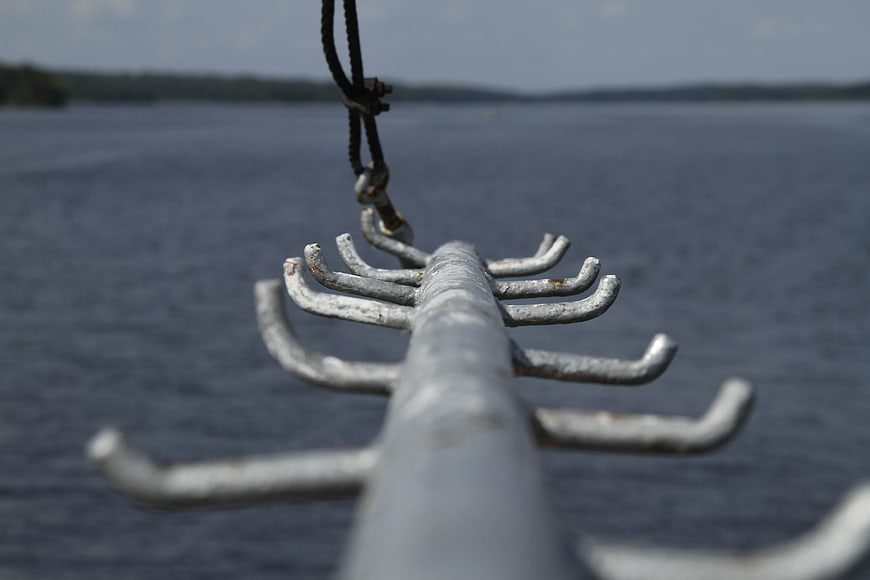 Close-up of metal boat oarlock against blurred lake background