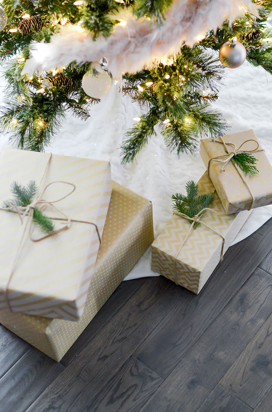 Christmas gifts under tree with lights and ornaments