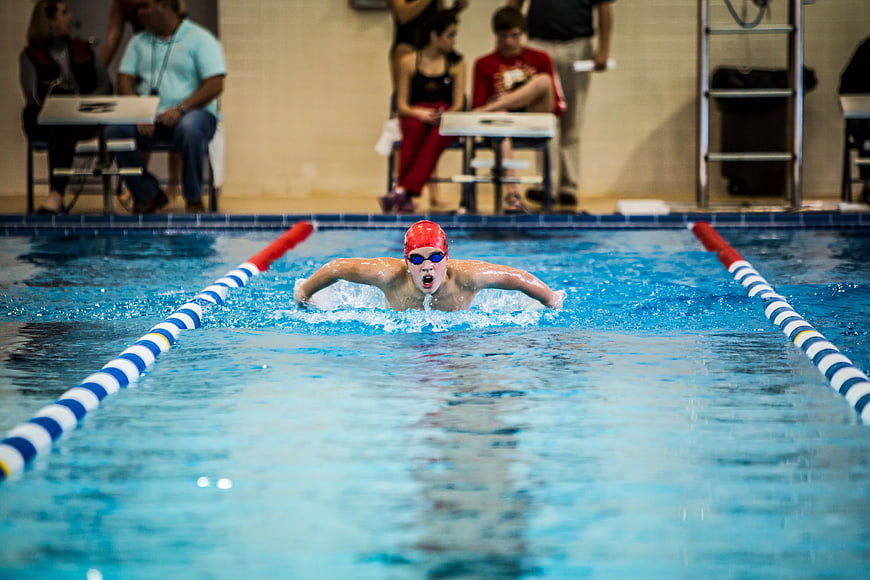 Young male swimmer performing butterfly stroke in pool