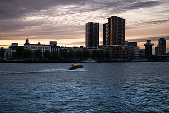 Rotterdam skyline at dusk with water taxi on the river