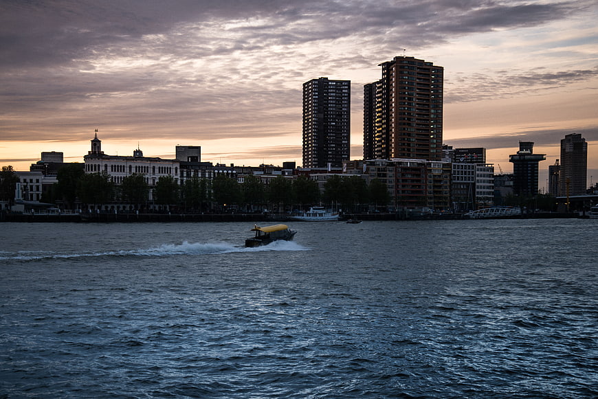Rotterdam skyline at dusk with water taxi on the river