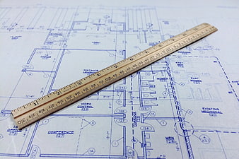 Wooden ruler on architectural blueprint floor plan