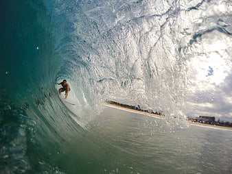 Surfer riding inside a massive ocean wave barrel
